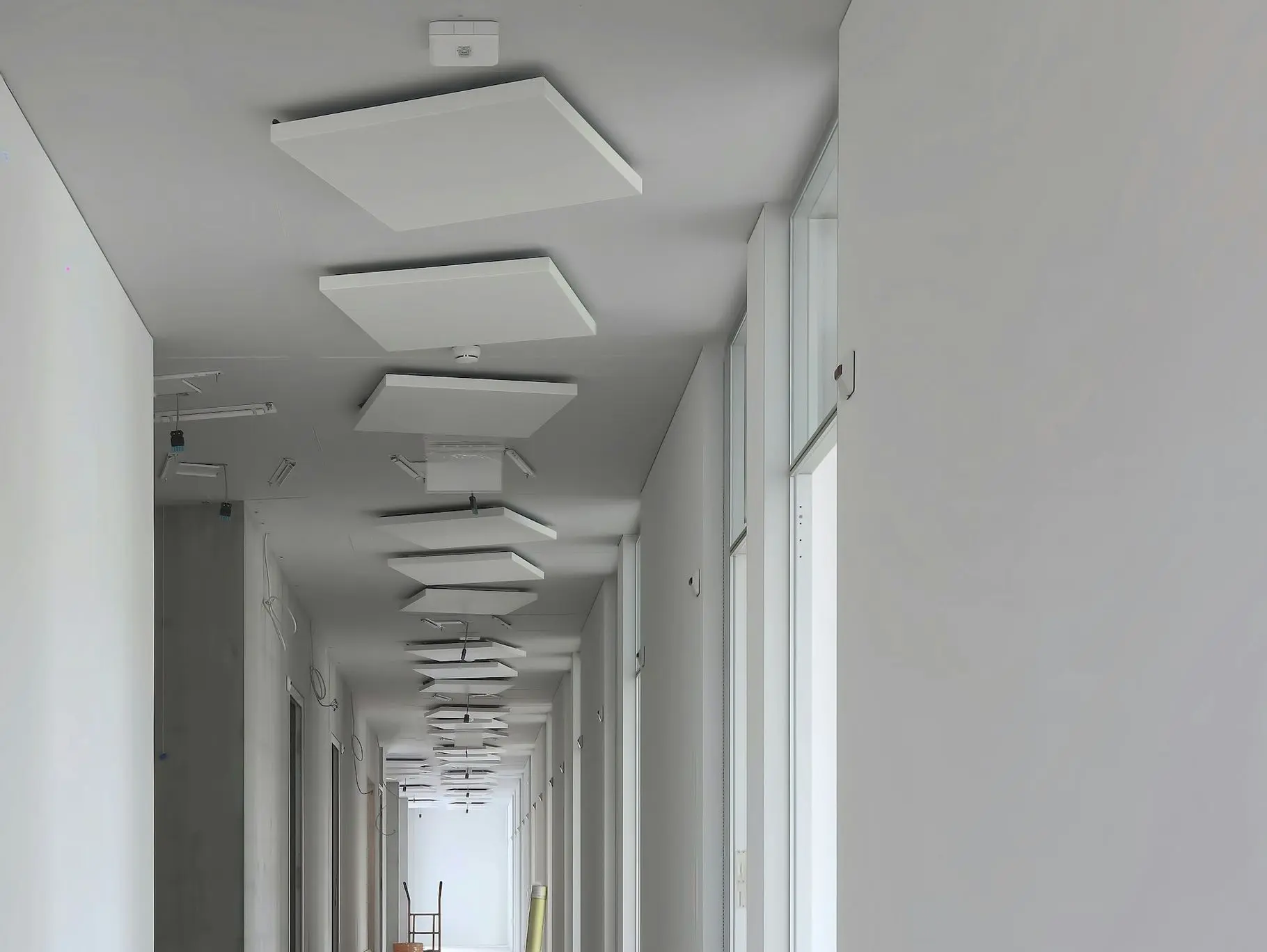 a long hallway with white walls and ceiling lights